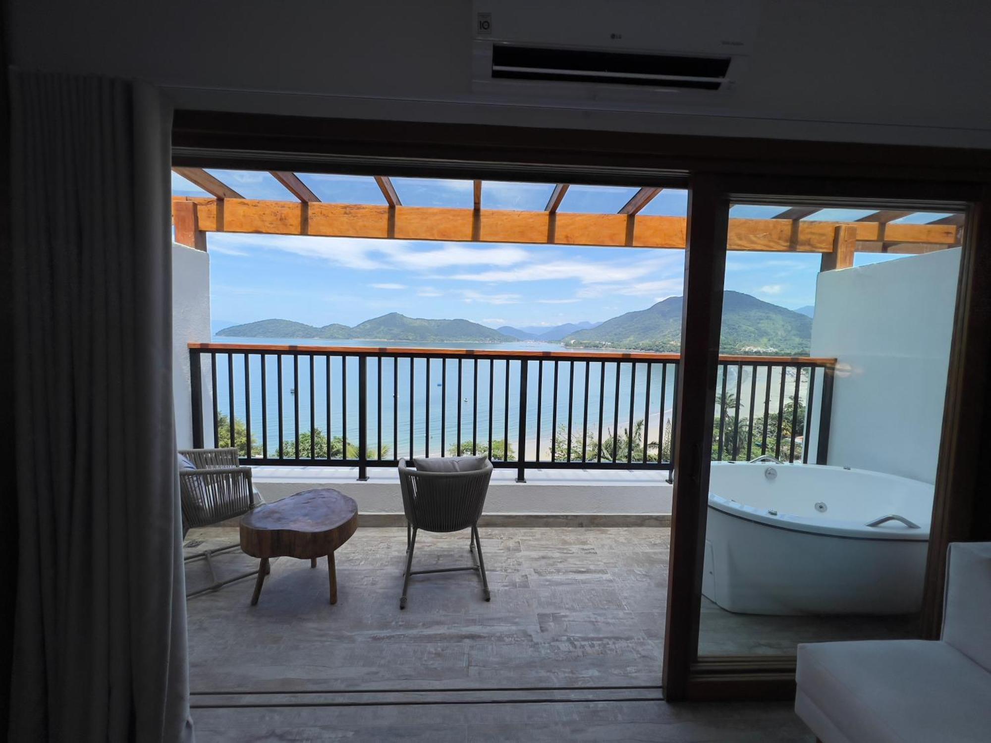 Quarto superior com cama king-size e vista do mar